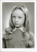Na ernobl fotografii asi ze 70. let 20. stol. je portrt mlad dvky
            s vlasy dlouhmi pod ramena a v tenkm svetku.