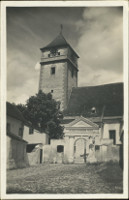 Na pohlednici je vidt mohutnou v kostela, st lodi a zdnou
            brnu na hbitov, kter je za zd.
