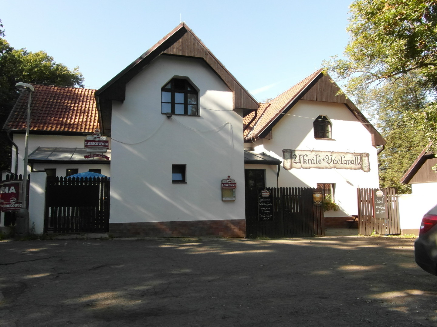 Na fotografii z vletu je restaurace U Krle Vclava IV. Je vidt nzev restaurace, npis
  Lobkowicz (pivo), prostor ped restaurac a stromy.