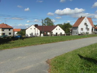 Na fotografii je vidt silnice prochzejc zatravnnou plochou.
          Domy jsou na severn stran vchodn sti nvsi.