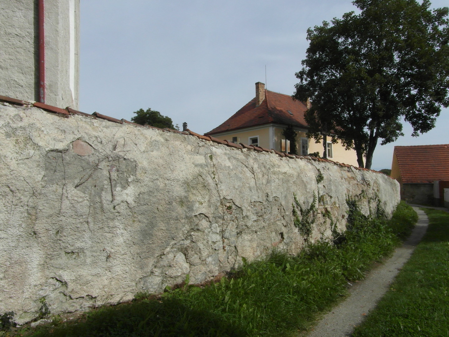 Na zbru fotografie z vletu je ulika, kter spojuje za hbitovem ulici Farn s ulic umavskou. Ze hbitova je zajmav tm, e je nahoe 
  z vnj strany zaoblen a zakonen hebeni jako stecha. Ulika jde do mrnho oblouku. Ze je na pr mstech porostl popnavou rostlinou. Na 
  konci je do dvou kmen rozvtven listnat strom. Za zd hbitova je velk okrov budova, kter je na rozcest umavsk a Farn ulice, a byla ji 
  popsna na pedchozch snmcch.