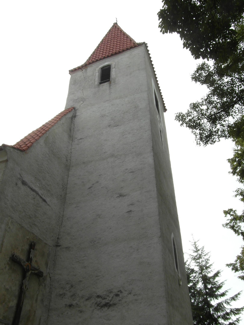 Na zbru fotografie z vletu je v kostela od pat, to znamen zblzka ze hbitova. V levm dolnm kout je vidt horn
  st ke z pedchozho obrzku. Napravo je listnat a vzadu jet jehlinat strom.