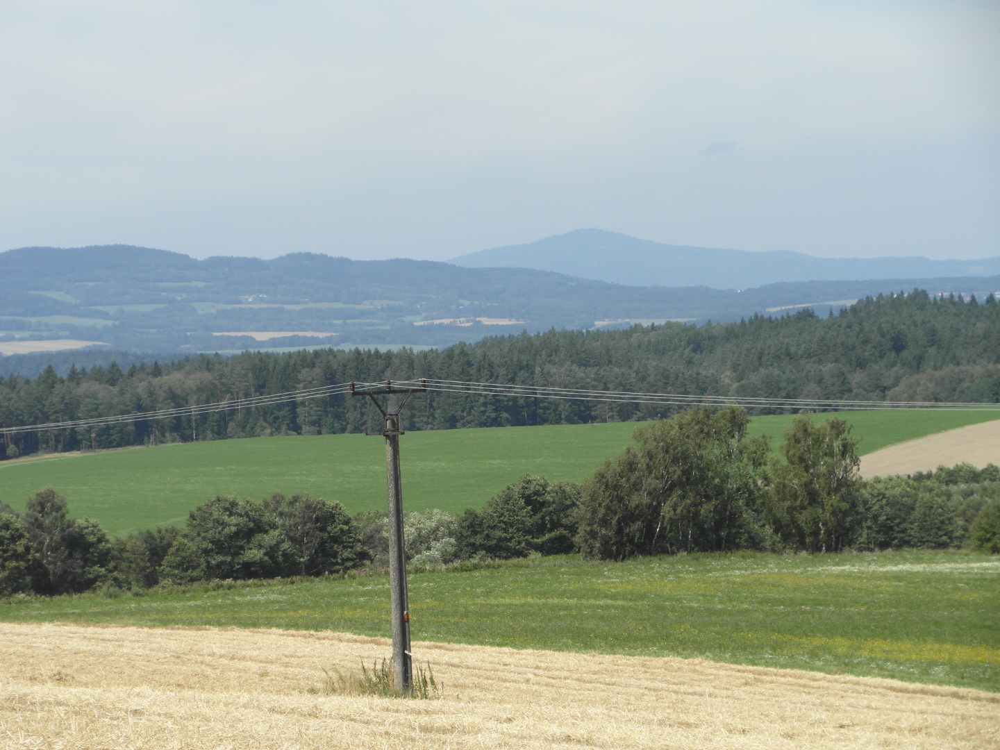 Na fotografii z vletu jsou 
  pole, louky, lesy a v dlce kopce. Tak je na n pkn vidt sloup a drty veden 
  vysokho napt.