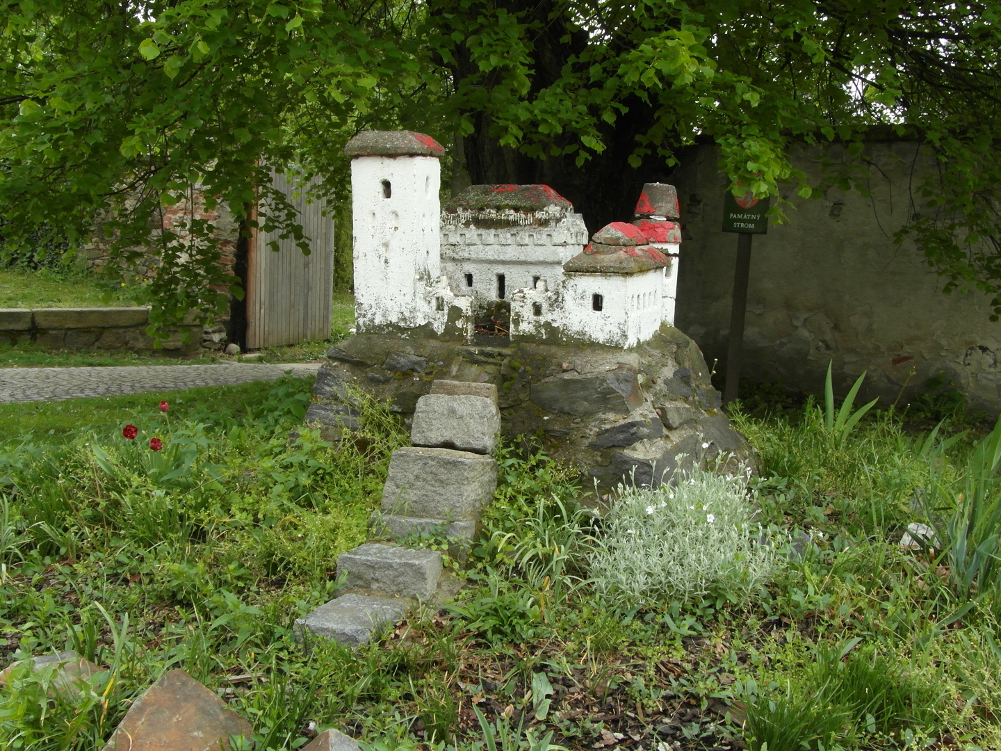 Na fotografii je skalka, schody a v pozad strom, u kterho se miniatura nachz.