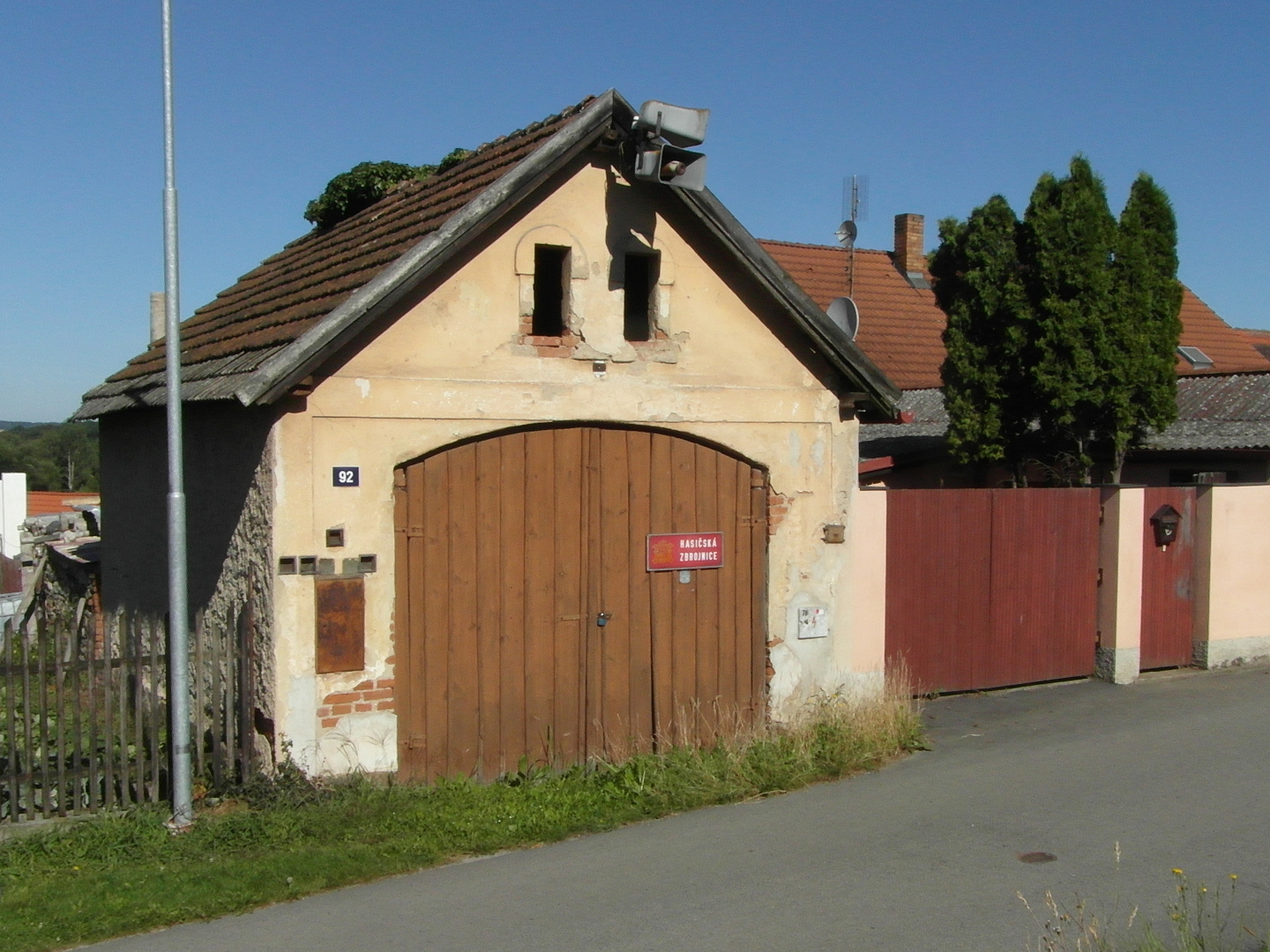 Hasisk zbrojnice je mal budova, jej znanou st eln stny zabraj devn vrata. Ve ttu jsou dv zk okna. erven plechov cedule s blm npisem
  m lut znak.