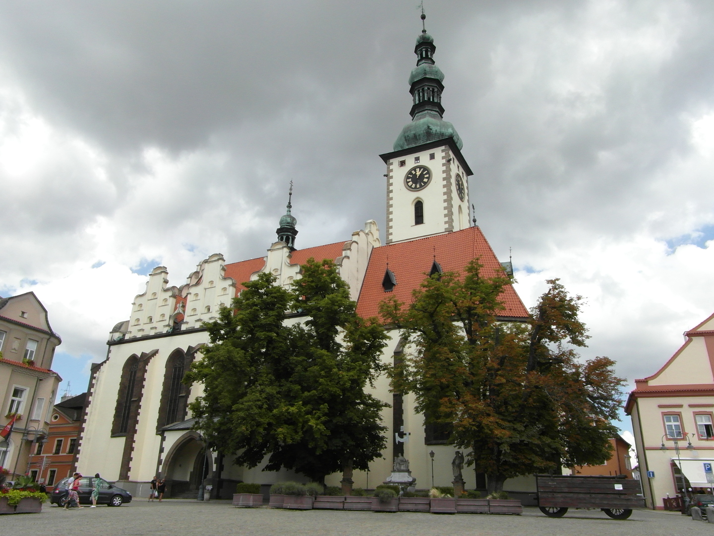 Na fotografii je v a lo kostela Promnn Pn. Kostel je bl. Na vi jsou bn pokryt mdnkou. st lodi kostela zakrvaj
          stromy. Napravo je st domu. Dm m bledou rovou barvu s ervenou vzdobou.